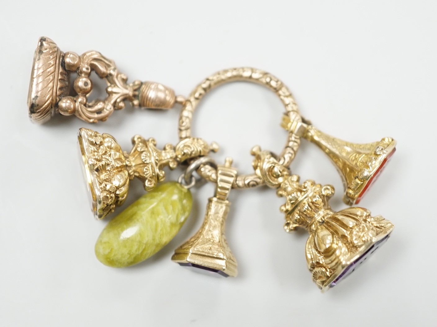 Four Victorian assorted yellow metal and gem set fob seals, including two amethyst(one carved with initials), one citrine and one carnelian (carved with monogram), together with a stone? charm and a gold plate mounted ci